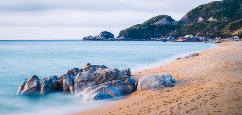 yakushima-inakahama-beach-rocks-sunset Soft evening light over rocks and golden sand at Inakahama Beach in Yakushima, Japan