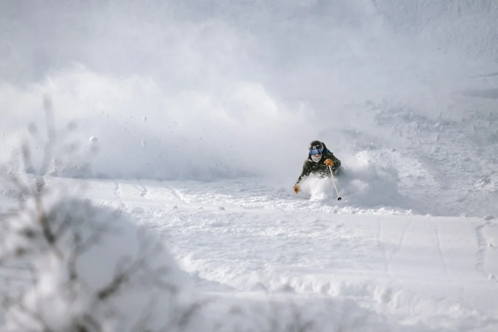 Skier captured sharply in bright snow with balanced exposure, an example of ski photography camera settings in action.