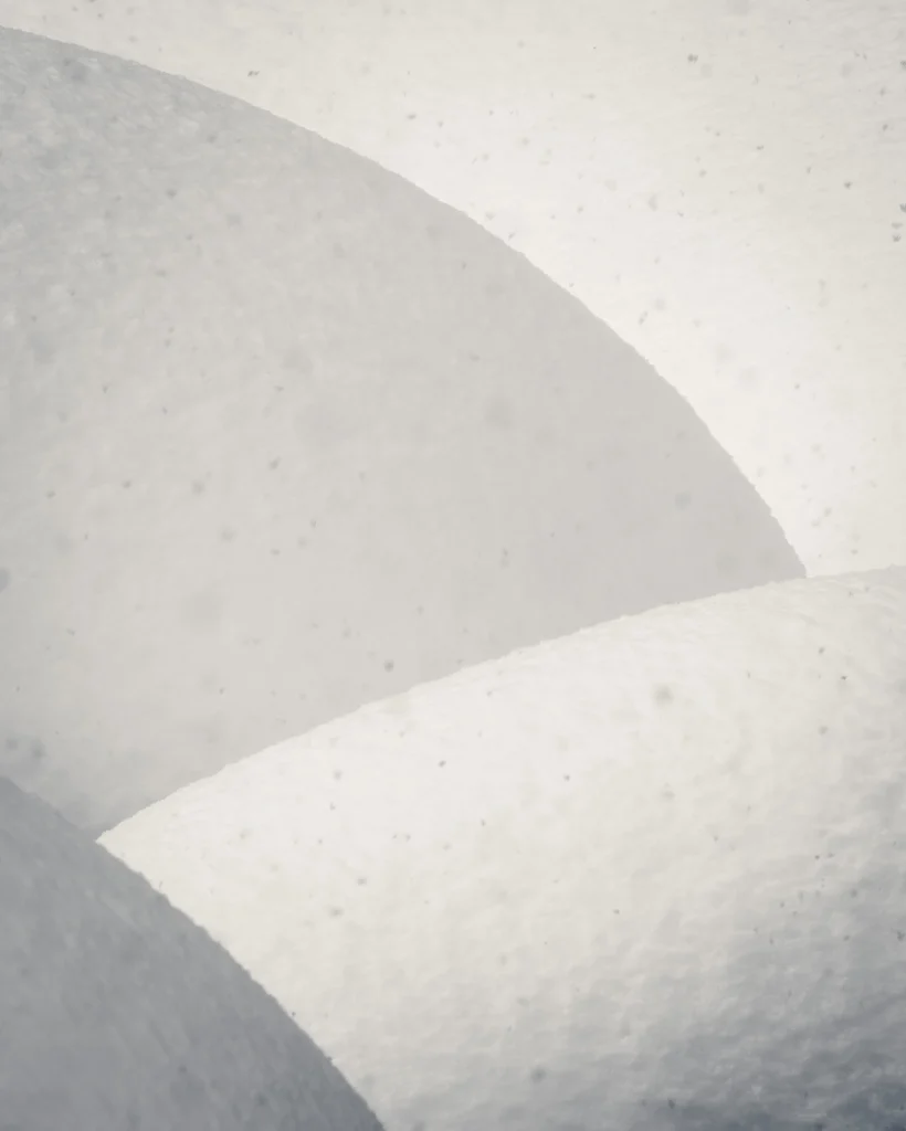 Abstract snow curves in soft winter light, showing how experimentation with composition and tone reveals new photographic possibilities.