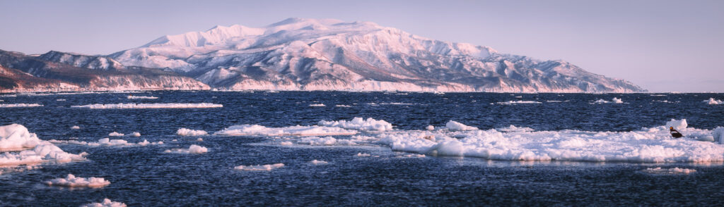 Drift ice along the coast of eastern Hokkaido in winter with snow-covered mountains in the distance