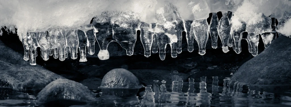 cicles hanging over a partially frozen river in winter in Hokkaido